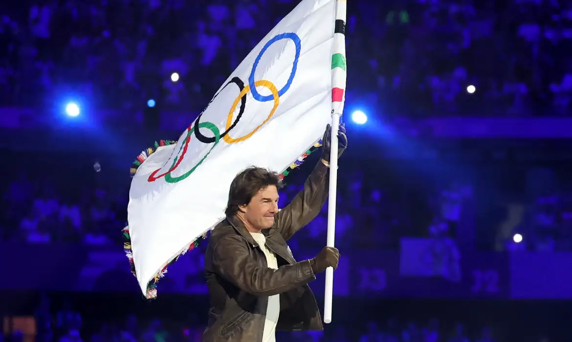 Ator Tom Cruise conduziu bandeira olímpica no Stade de France